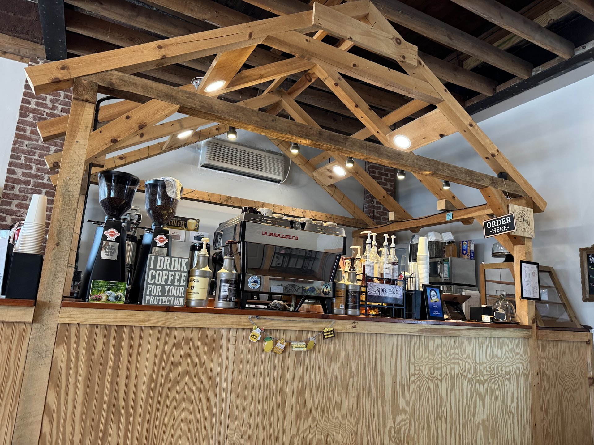 Sunlit coffee bar beneath exposed timber beams