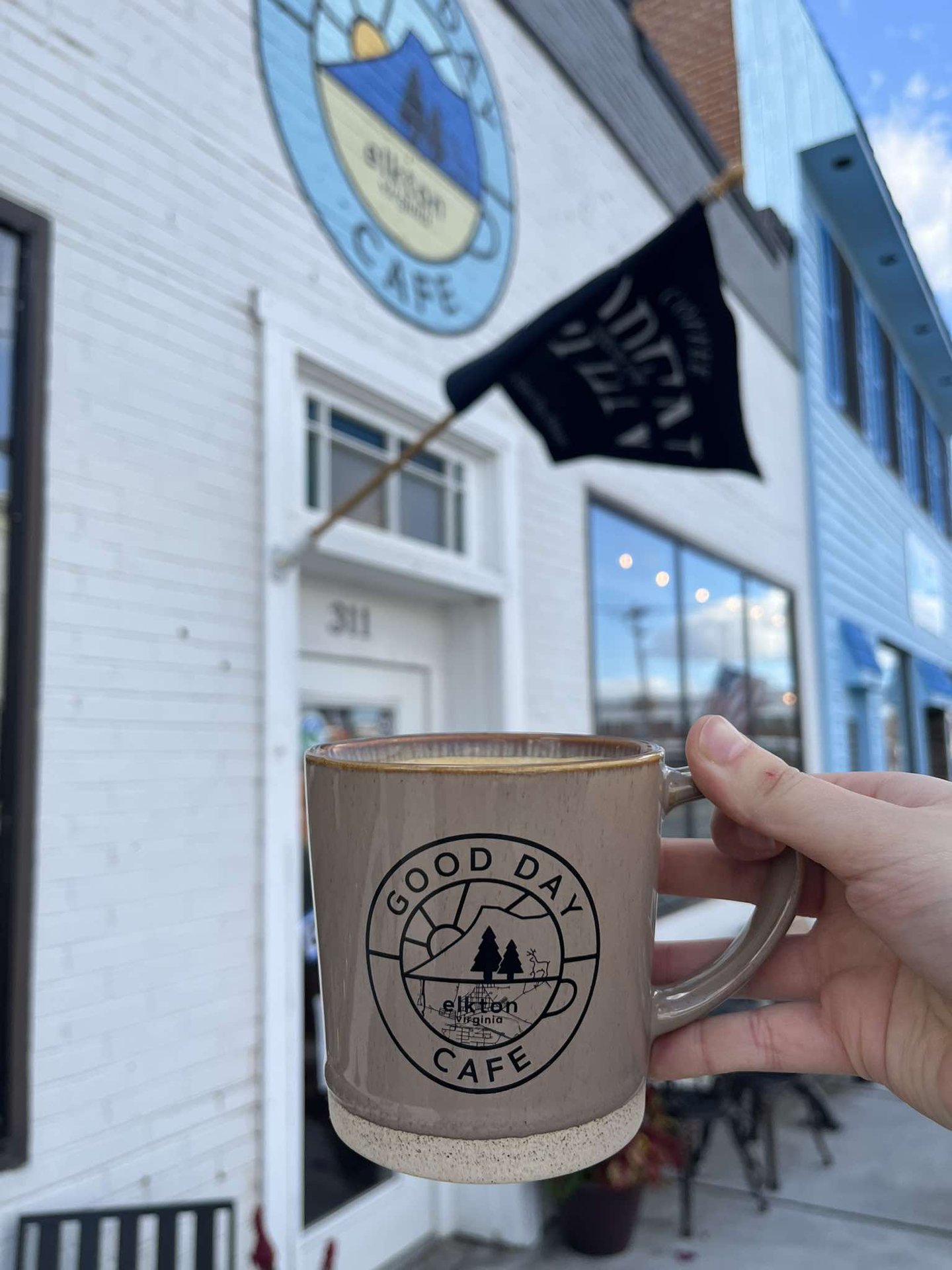 A Good Day Café mug held outside the Elkton storefront
